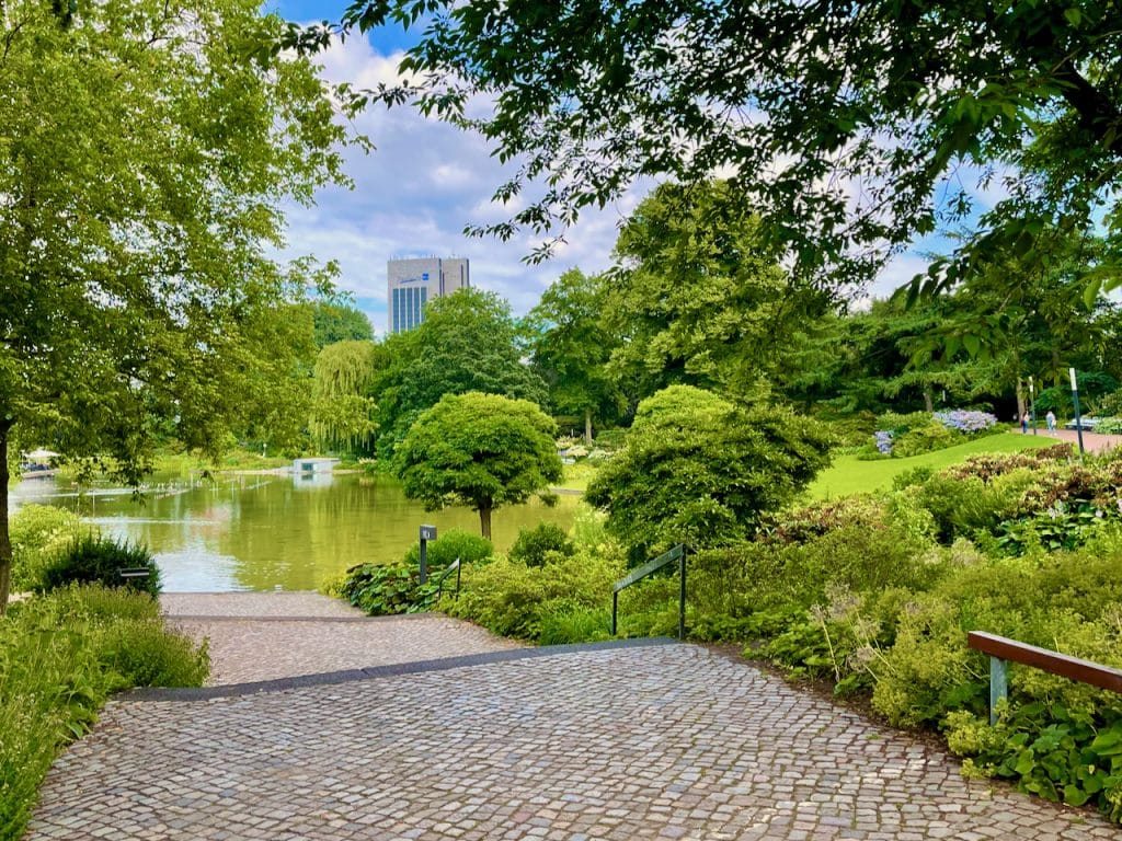 Immerse yourself in a picturesque piece of nature in the middle of Hamburg - that's possible if you lace up your running shoes and explore the enchanting running route through Planten un Blomen. The extensive park is a real jewel of the city and offers an idyllic environment for relaxed jogging or walking amidst magnificent plants, colorful flower beds and impressive water landscapes. The well-groomed paths lead past numerous attractions that make running an unforgettable experience. Discover the rose garden with its more than 300 varieties of roses, the Japanese garden, which radiates Far Eastern flair, or the impressive water light organ, which creates an atmospheric atmosphere, especially in the evening hours. Photo: Sascha Tegtmeyer