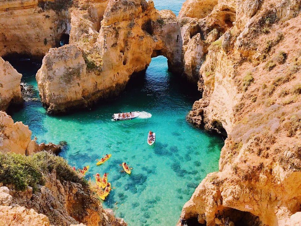 Portugal ist ein wunderschönes Land, das Besucher:innen viel zu bieten hat – und die Algarve ist ein großartiger Ort, um sich zu entspannen und deinen Urlaub zu genießen. bird s eye view photography of cove